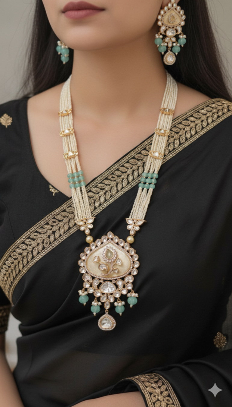 Woman wearing a black saree with gold and green jewelry